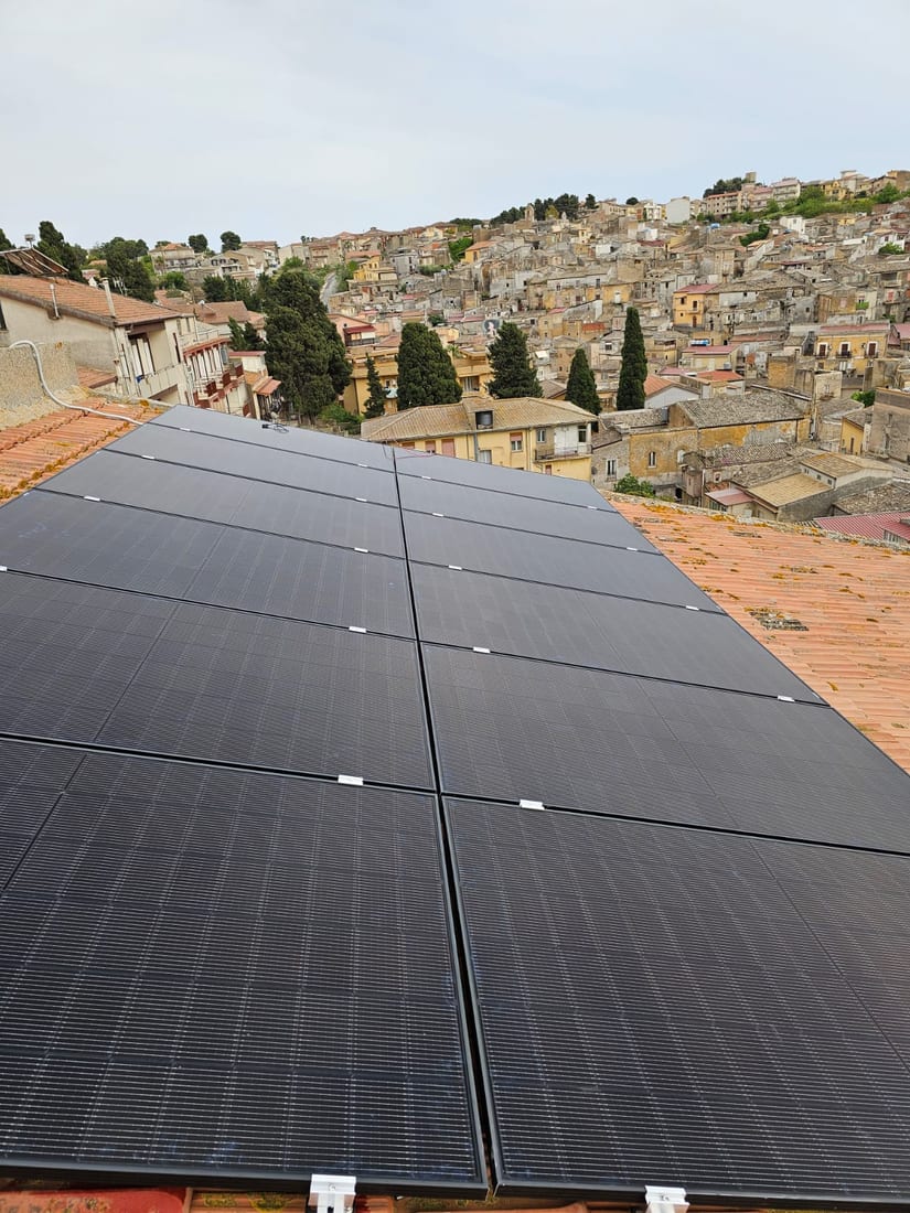 Moduli fotovoltaici posati su un tetto, con il paese sullo sfondo