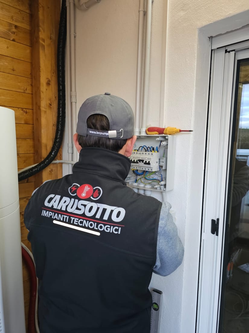 Tecnico di Carusotto Impianti al lavoro su un quadro elettrico in un'abitazione